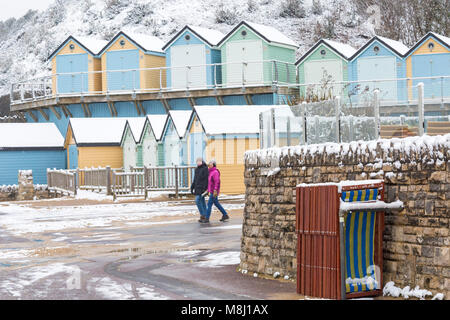 Bournemouth, Dorset, UK. 18 mars 2018. Météo France : bête de l'Est 2 apporte beaucoup de neige à la plage de Bournemouth - couple devant des cabanes de plage et chaises longues au crédit d'Alum Chine : Carolyn Jenkins/Alamy Live News Banque D'Images