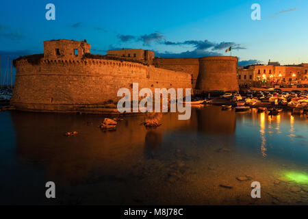 Crépuscule du soir à Gallipoli, province de Lecce, Pouilles, Italie du sud. Voir des murs de la forteresse de château médiéval Angevine-Aragonese Banque D'Images