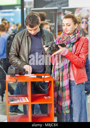 KIEV, UKRAINE - 08 octobre 2017 : les visiteurs professionnels non reconnus à l'essai d'appareils photographiques sur stand Canon au cours de l'ECO 2017, le plus grand electron Banque D'Images