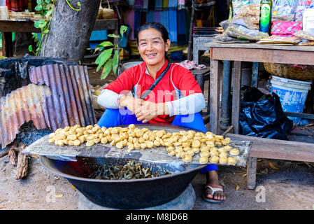 Siem Reap, Cambodge - janvier 03, 2017 : A smiling girl la vente de sucre de palme au village des producteurs Banque D'Images