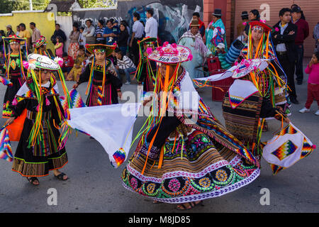 Traditionnellement les femmes habillées de couleurs vives dans la danse rue principale de Mallassa dans défilé du festival Banque D'Images