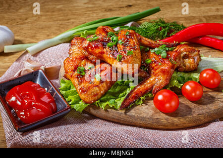Ailes de poulet frit et des légumes frais sur une table en bois Banque D'Images