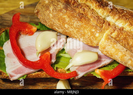 Sandwich au jambon et légumes sur fond de bois Banque D'Images