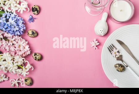 Table de Pâques printemps avec des fleurs de jacinthes sur fond rose. Banque D'Images