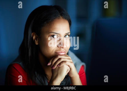 Portrait of young businesswoman looking at camera while working on computer Banque D'Images