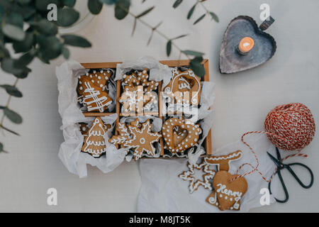 Une boîte de biscuits au gingembre sur une table avec une bougie Banque D'Images