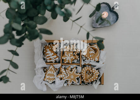 Une boîte de biscuits au gingembre sur une table avec une bougie Banque D'Images