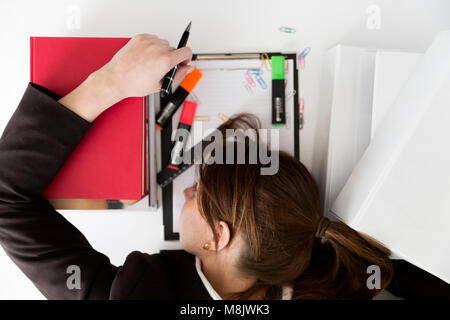 Fatigué de la charge de businesswoman with paperwork Banque D'Images