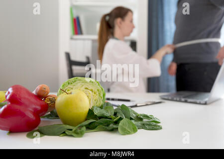 Régime alimentaire Légumes et nutrition concept de médicaments. Mesures de la taille du patient nutritionniste et offre des légumes sains régime alimentaire. Banque D'Images