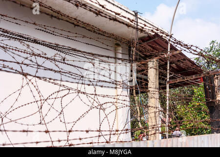 Les barbelés, le fil barbelé et electricified la clôture autour du périmètre du musée du génocide de Tuol Sleng, à Phnom Penh, où les Khmers rouges, sous la direction de Pol Pot, torturé des milliers de personnes avant de les tuer. Banque D'Images