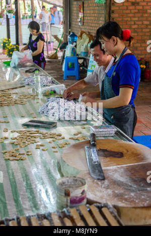 Bonbons en forme de personnes de coco à la main avant leur conditionnement et l'emballage, au Vietnam Banque D'Images