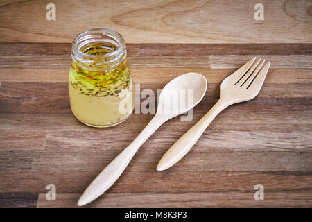 Une paire de fourchette et cuillère en bois avec un verre tasse de salade vinaigrette Banque D'Images