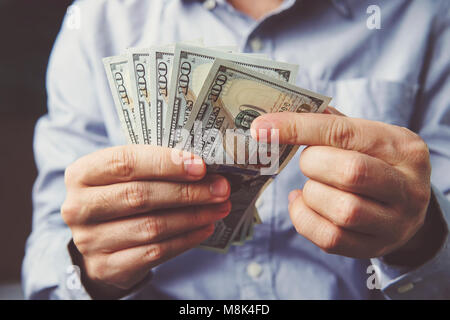 Comptage des billets de dollar sur les mains en bois surface. Office worker considère le salaire en dollars. 500 dollars américains l'homme d'wi. Banque D'Images