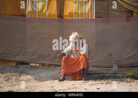 VARANASI, Inde. 28 février 2017 : l'ermite, un sadhu, est assis en méditant sur l'opposé de l'Varanasi rives du fleuve saint Ganges Banque D'Images