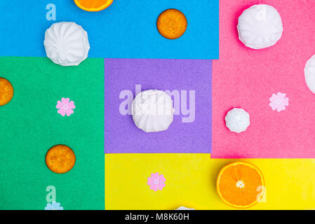 Ronde différents bonbons - cookies, meringue, guimauve sur fond lumineux multicolores. Bonbon sucré le minimalisme concept de géométrie. Vue de dessus, selective focus. Banque D'Images