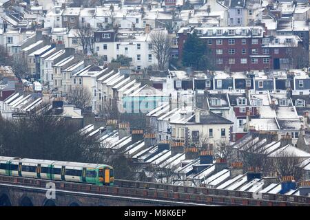 Les maisons couvertes de neige sont considérées comme un train traverse la route de Londres à Brighton Viaduc.18 Mar 2018. Photo par James Boardman Banque D'Images