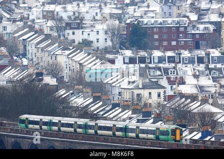 Les maisons couvertes de neige sont considérées comme un train traverse la route de Londres à Brighton Viaduc.18 Mar 2018. Photo par James Boardman Banque D'Images