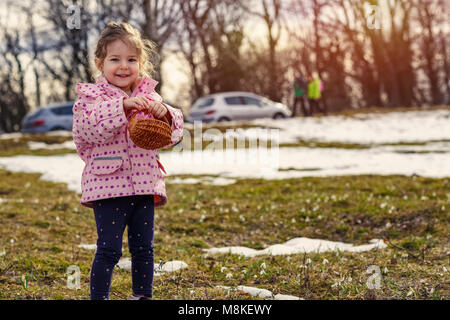 Young smiling girl picking snowdrop des fleurs au printemps forest Banque D'Images