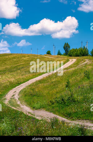 Route de campagne le long de la colline. belle campagne paysage rural en été. beau bleu ciel d'été avec fluffy clouds Banque D'Images