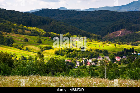 Petit village dans les montagnes des Carpates. beau paysage et les collines boisées et les champs agricoles Banque D'Images
