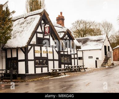 Noir et blanc La neige a couvert la moitié des maisons à colombages et le Lion Blanc Inn dans le pittoresque village de Barthomley Cheshire Angleterre pendant l'hiver Banque D'Images