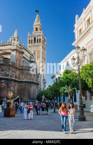 Séville, Andalousie, Espagne : les gens passent devant la cathédrale gothique et la Giralda sur la Plaza del Triunfo square. Banque D'Images