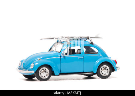 FARO, PORTUGAL : 1er février 2018 - jouet vintage Blue beetle modèle voiture voiture avec surf board isolé sur un fond blanc. Banque D'Images
