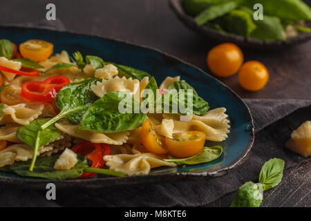 Salade de farfalle pâtes italiennes avec des légumes et les épinards dans une belle plaque d'époque. Banque D'Images