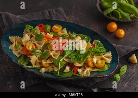 Salade de farfalle pâtes italiennes avec des légumes et les épinards dans une belle plaque d'époque. Banque D'Images