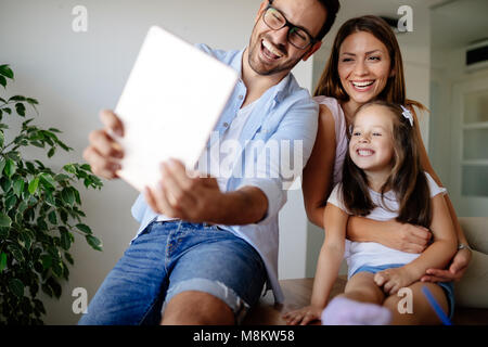 Famille heureuse de prendre dans leur maison selfies Banque D'Images