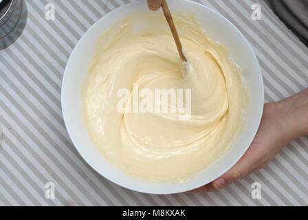 Mélanger la pâte à la cuisson des gaufres, d'Œufs et de lait, dans un bol en verre. La préparation des aliments Photo Processus Banque D'Images