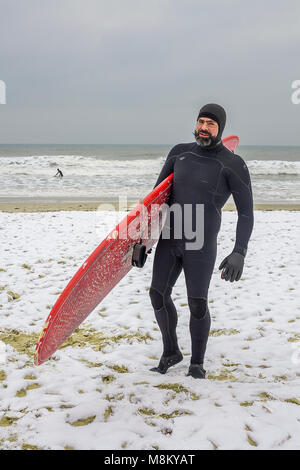 Bournemouth, Royaume-Uni. 18 mars 2018. Surfer sur la plage de Bournemouth sur un jour froid et neigeux Crédit : Paul Ashby/Alamy Live News Banque D'Images