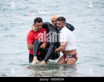 Un triathlète handicapé est aidé hors de l'eau après avoir terminé l'étape de la nage à l'ETU triathlon sprint triathlon coupe européenne sur Gran Canaria Banque D'Images