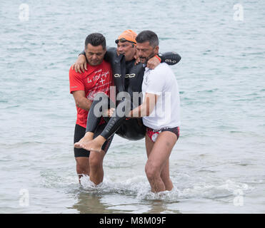 Un triathlète handicapé est aidé hors de l'eau après avoir terminé l'étape de la nage à l'ETU triathlon sprint triathlon coupe européenne sur Gran Canaria Banque D'Images