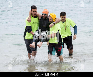 Un triathlète handicapé est aidé hors de l'eau après avoir terminé l'étape de la nage à l'ETU triathlon sprint triathlon coupe européenne sur Gran Canaria Banque D'Images