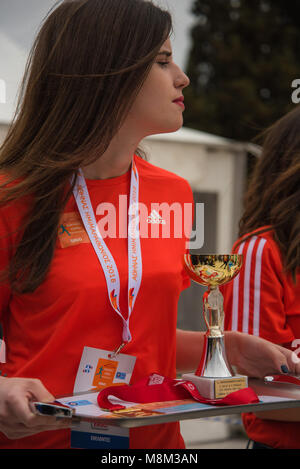 Athènes, Grèce. 18 Mar, 2018. Une jeune fille bénévole, tient la médailles pour les participants qui ont terminé dans les premières places.Demi-marathon d'Athènes avec 5km de course et 3km de course. Des milliers de citoyens ont participé à la grande manifestation sportive qui a débuté dans le centre de la capitale et a été co-organisé par SEGAS, la municipalité d'Athènes et de l'Organisation de la Culture, du sport et de la jeunesse de la municipalité d'Athènes. Le départ a eu lieu à la place Syntagma. Credit : Vangelis/Evangeliou SOPA Images/ZUMA/Alamy Fil Live News Banque D'Images