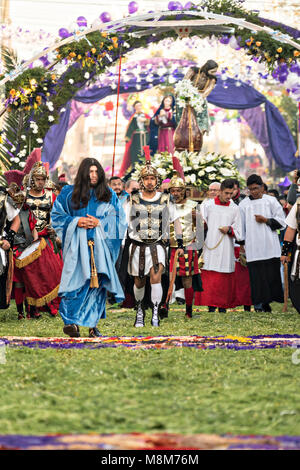 Habillé comme Jésus et escorté par des Centurions Romains fidèles catholiques marcher sur des tapis de fleurs pendant l'Notre Seigneur de la colonne procession marquant le début de la Semaine Sainte, le 18 mars 2018 à San Miguel de Allende, Mexique. Semaine sainte dure deux semaines dans le centre du Mexique, le festival de la ville. Banque D'Images