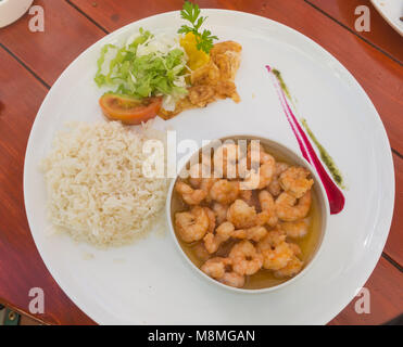 Close up tasty poêlée de crevettes roses cuites avec de l'ail ou gambas assaisonnées d'huile d'olive et de fines herbes ont servi de riz cuisiné un démarreur de fruits de mer sur plaque pour Banque D'Images