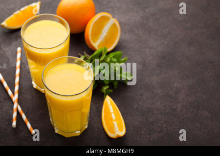 Deux verres de jus d'orange fraîchement pressé et de menthe sur un fond brun foncé. Top View with copy space Banque D'Images