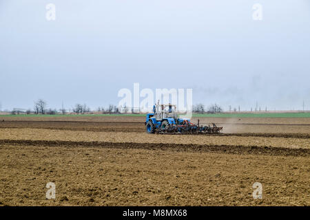 Lush et desserrer le sol sur le terrain avant de semer. Le tracteur laboure un champ avec une charrue Banque D'Images