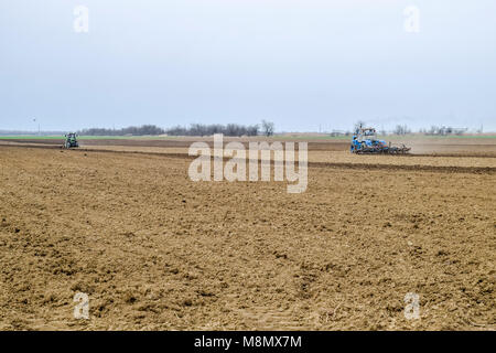 Lush et desserrer le sol sur le terrain avant de semer. Le tracteur laboure un champ avec une charrue Banque D'Images