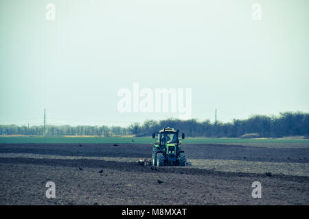 Lush et desserrer le sol sur le terrain avant de semer. Le tracteur laboure un champ avec une charrue Banque D'Images