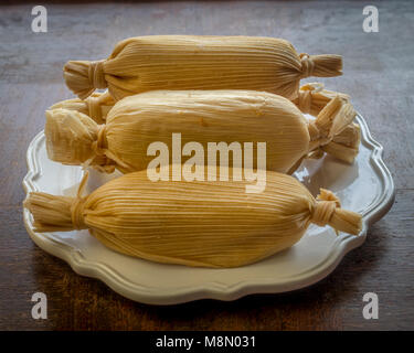 Unwrapped tamales mexicains empilées en plaque blanche sur grunge vue d'au-dessus de table en bois - concept d'aliments ethniques Banque D'Images