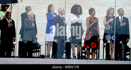 De gauche à droite : représentant des États-Unis John Lewis (démocrate de la Géorgie), l'Ambassadeur Andrew Young, l'ancien président américain Jimmy Carter, Lynda Bird Johnson Robb, ancien Président des États-Unis Bill Clinton, Oprah Winfrey, Première Dame Michelle Obama, l'Ambassadeur Caroline Kennedy, et le président des États-Unis Barack Obama écouter l'hymne national à la cérémonie que la liberté retentisse sur les marches du Lincoln Memorial pour commémorer le 50e anniversaire de la Marche sur Washington pour l'emploi et la liberté. Credit : Ron Sachs / CNP /MediaPunch Banque D'Images