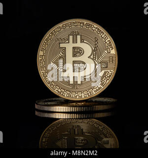 Les bitcoins pour pièces d'or empilés BTC cryptocurrency noire sur une surface réfléchissante à l'arrière-plan Banque D'Images