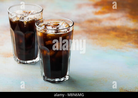 Café de glace dans un grand verre avec versé sur de la crème et les grains de café. Boisson d'été à froid sur un fond bleu rusty with copy space Banque D'Images