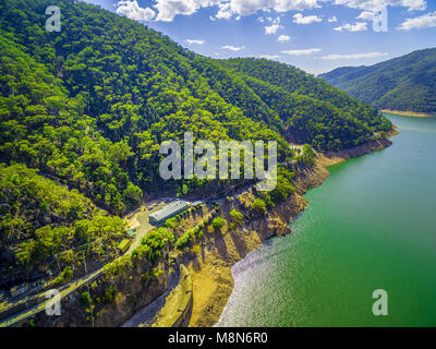Lac et collines boisées sous les nuages blancs moelleux sur journée d'été lumineux Banque D'Images