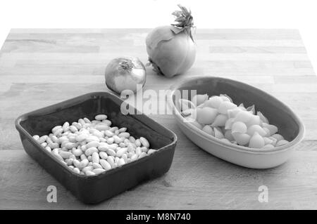 Ingrédients pour 'Pasta e fagioli' pasta, les haricots et les oignons sur une frontière en bois brut, rétro B&W Banque D'Images