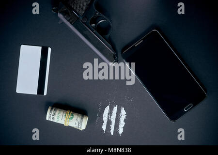 Téléphone mobile, de drogues comme la cocaïne en poudre, gun, carte de crédit et de l'argent sur le tableau noir Banque D'Images