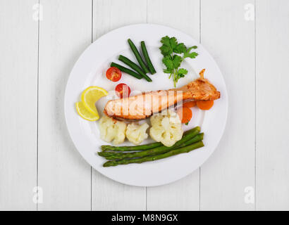 Saumon grillé avec des légumes sur la table rustique en bois blanc. Vue d'en haut Banque D'Images